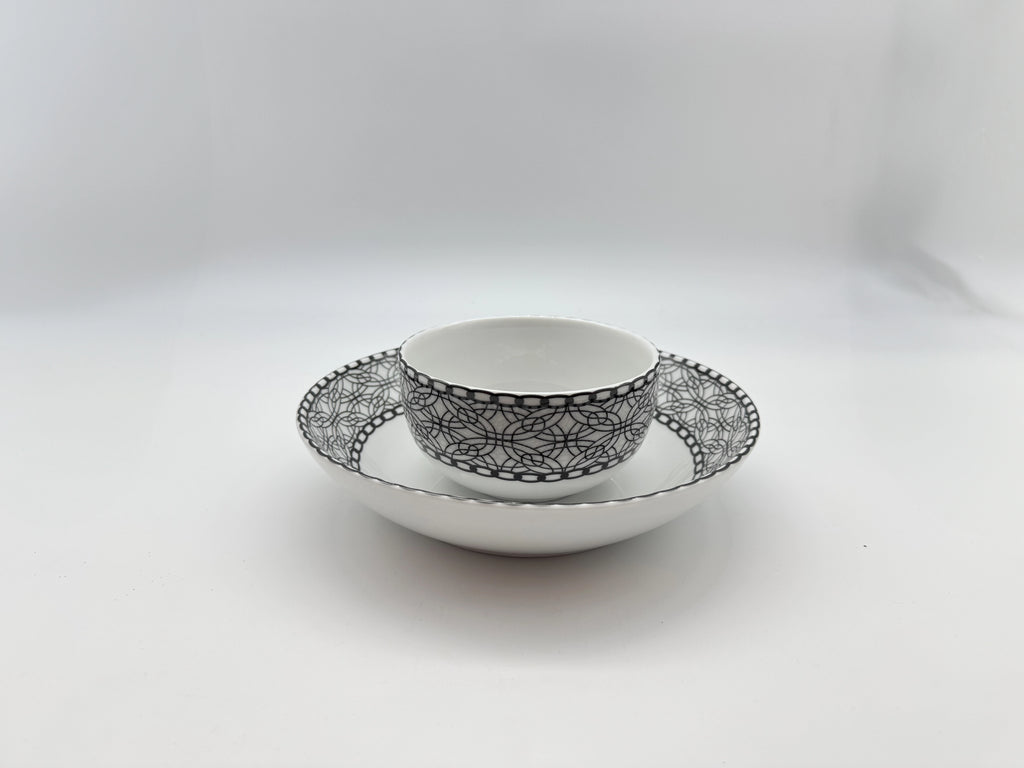 Porcelain bowl placed on matching deep plate with black lace pattern