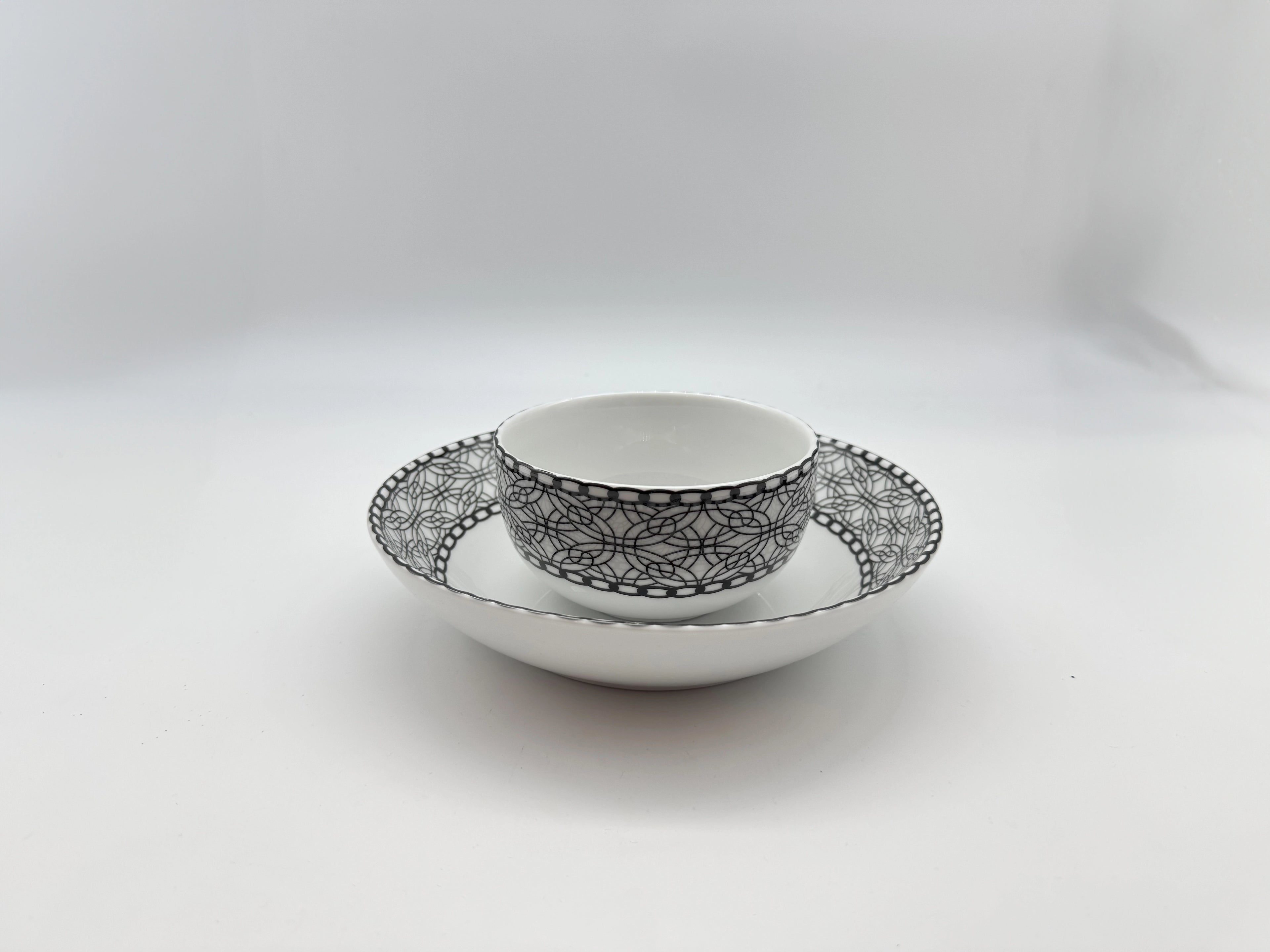 Porcelain bowl placed on matching deep plate with black lace pattern