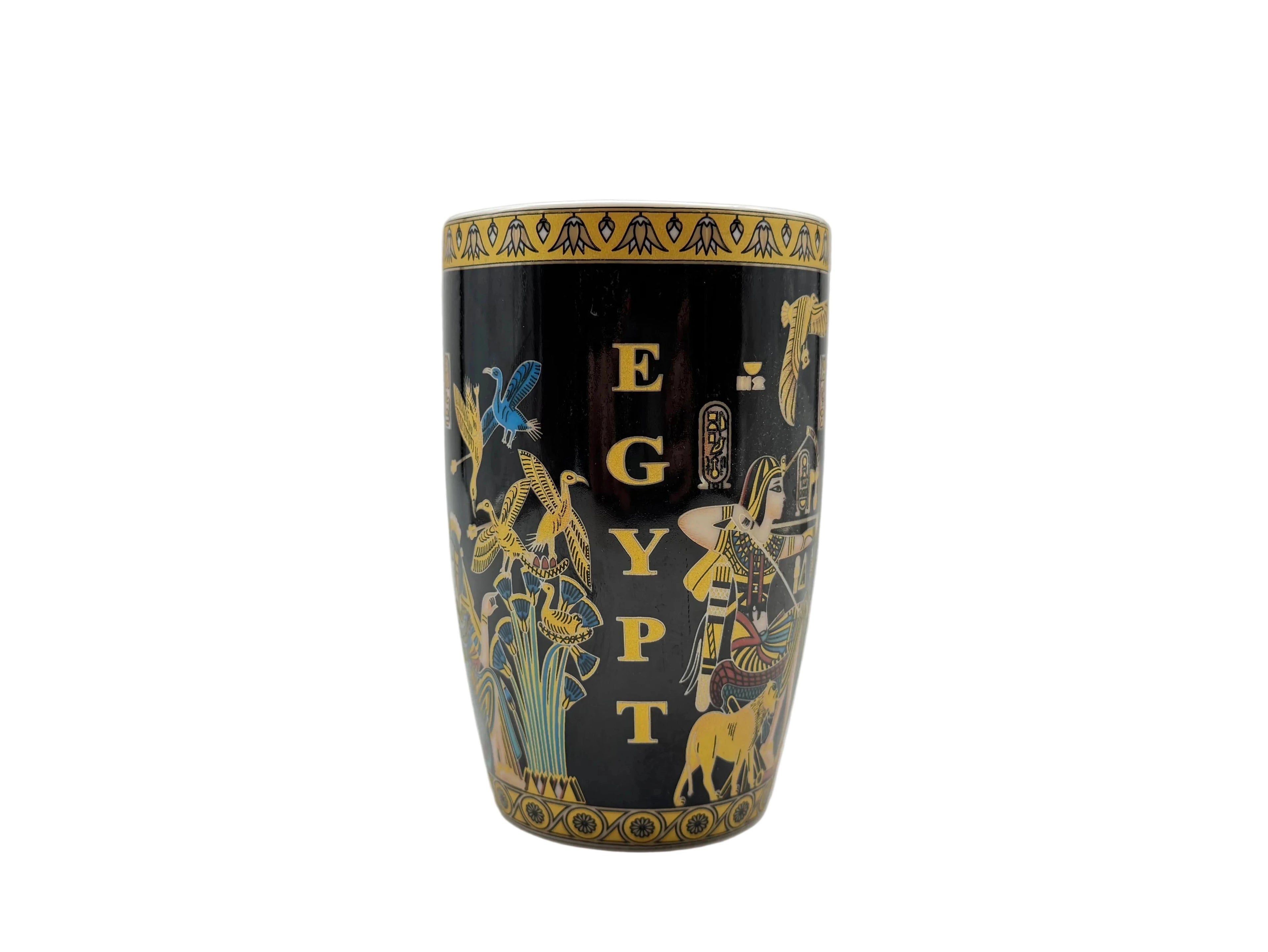 Side profile of the Mesu Hunter Mug showing the vertical ‘EGYPT’ lettering, golden birds, and papyrus plants on a glossy black surface
