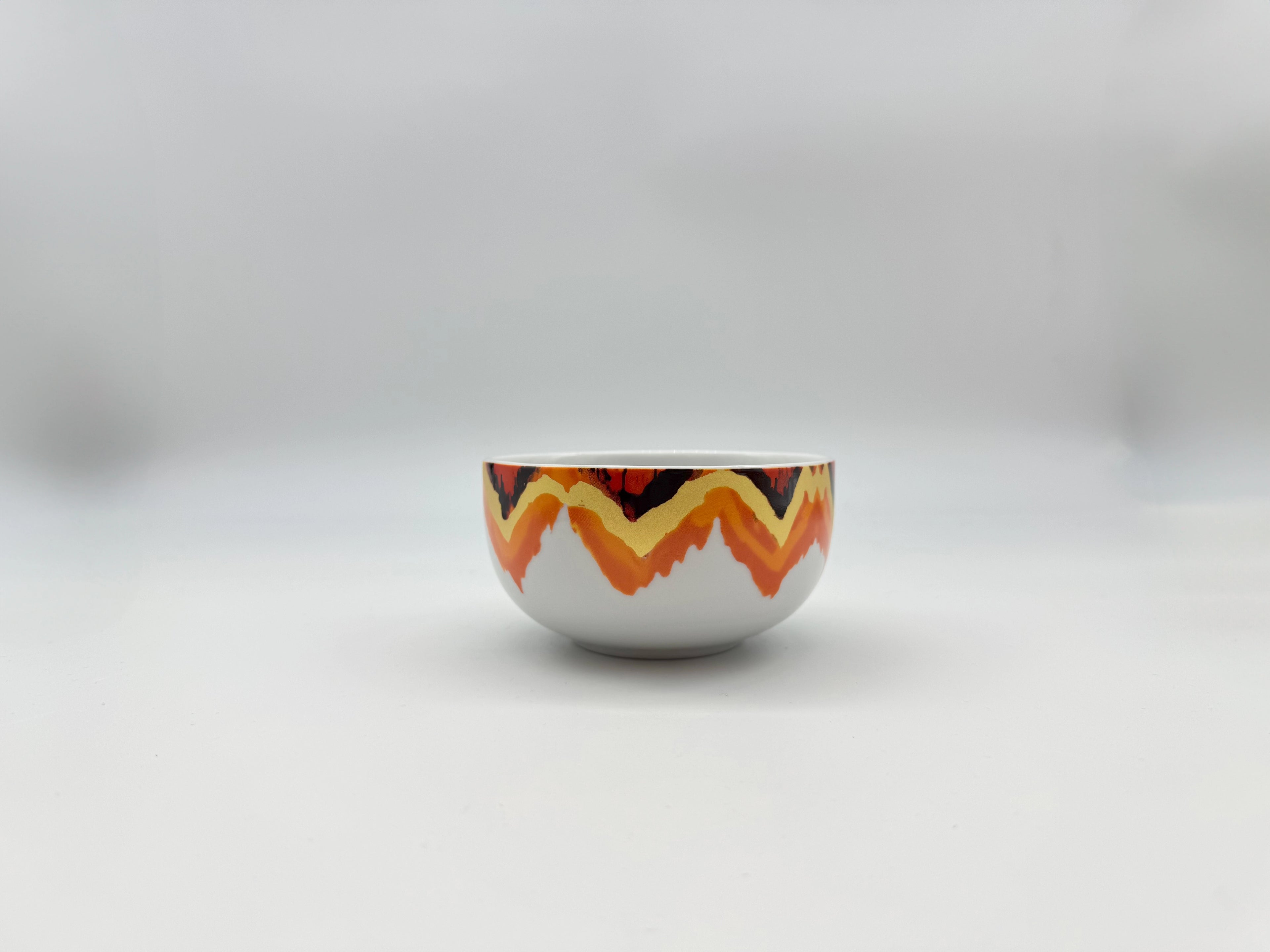 Front view of Sunset Zigzag porcelain soup bowl with warm-toned geometric design